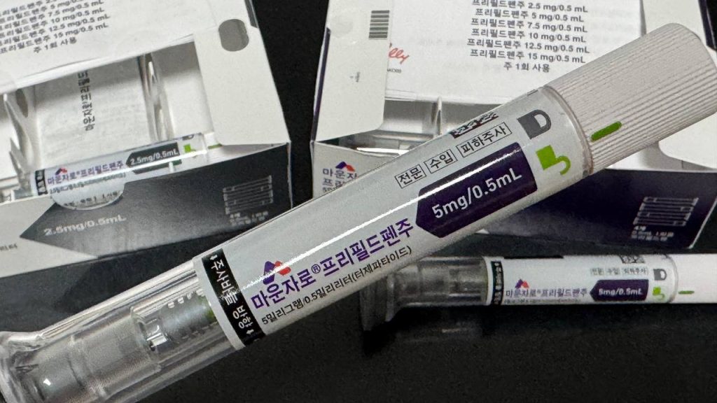 본문의 마운자로 증량 및 5mg 투약 후기 단락에 위치한 실물 사진으로, 한글로 '마운자로 프레필드펜주 5mg/0.5mL'라고 명확히 인쇄된 흰색 종이 패키지 상자가 놓여 있고, 그 앞에 패키지에서 꺼낸 실제 마운자로 5mg 주사 펜 한 개가 놓여 있는 모습.