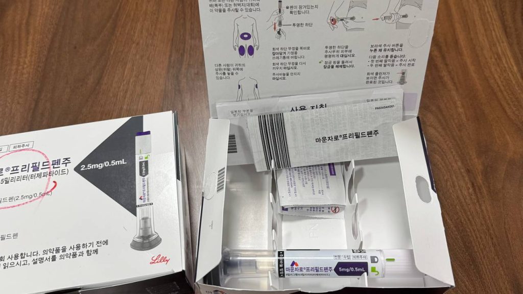 개봉된 마운자로 5mg 프리필드펜 패키지 실물 사진. 보라색 5mg 주사 펜의 상세한 모습과 주사 직후 피부 발진 및 부작용 예방을 위한 올바른 마운자로 맞고 샤워 루틴 가이드 설명 이미지.