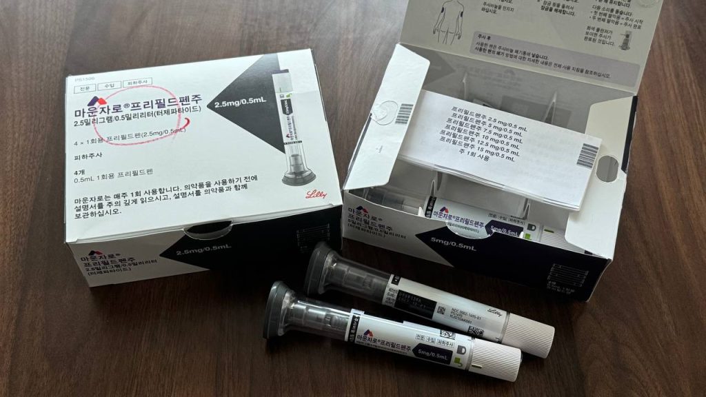 울산 마운자로 성지 병원 약국 처방 마운자로 2.5mg 정품 박스(왼쪽)와 패키지가 열려 내부 구성품이 보이는 5mg 박스(오른쪽), 그리고 그 앞에 나란히 놓인 5mg 프리필드펜 주사기 2개 실물 사진