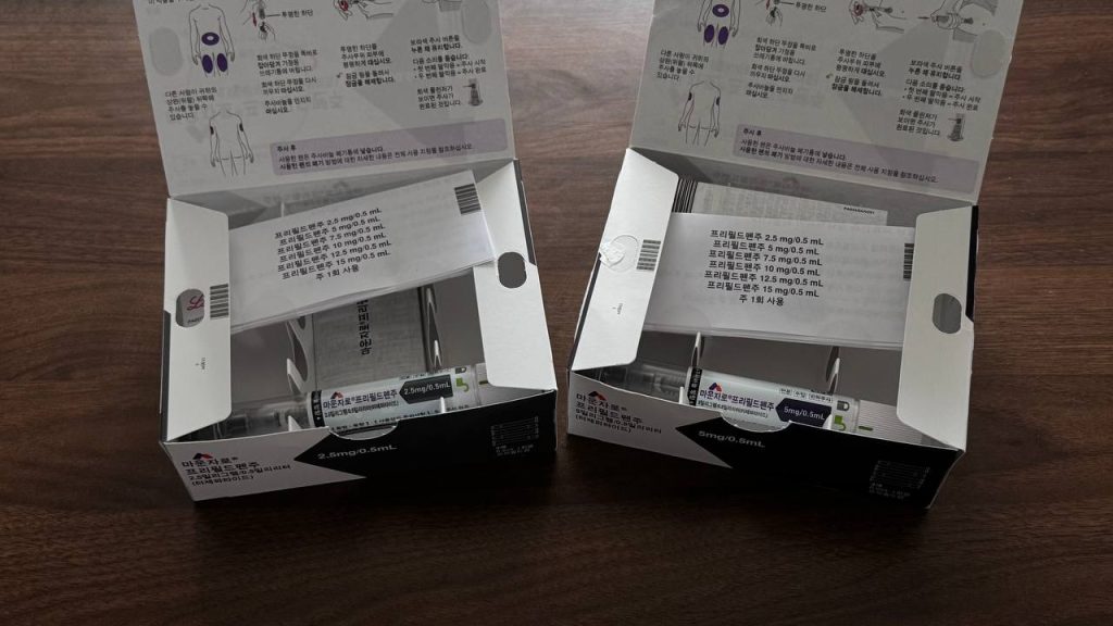 마운자로 성지 병원 및 약국에서 처방받은 마운자로 2.5mg 및 5mg 용량별 포장 상자를 개봉하여 제품 설명서와 프리필드펜을 확인하는 모습